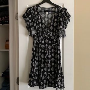 Black with white print mini dress. Slight ruffled short sleeves and bottom.